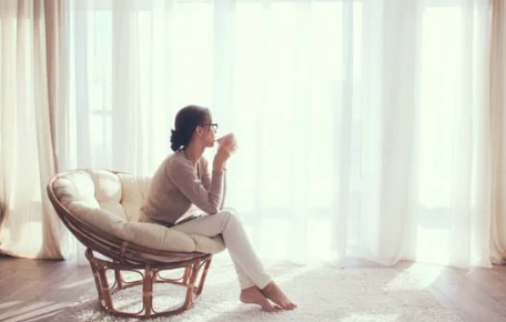 A woman sipping coffee mug looking at the window showing relief from High Functioning Anxiety after therapy at Magnolia Psychotherapy in New Providence NJ