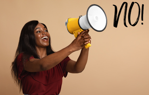 A woman smiling and holding a megaphone announcing a firm "No!" Need help setting boundaries. Reach out to Magnolia Psychotheapy today