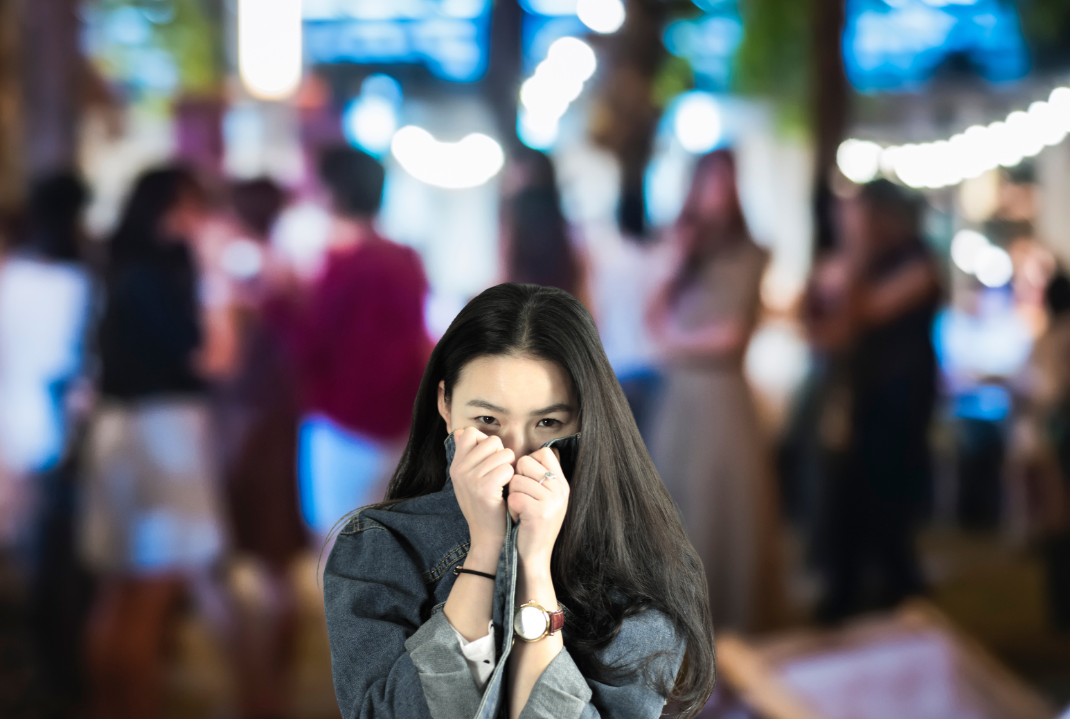 Woman hiding face at a party from social anxiety