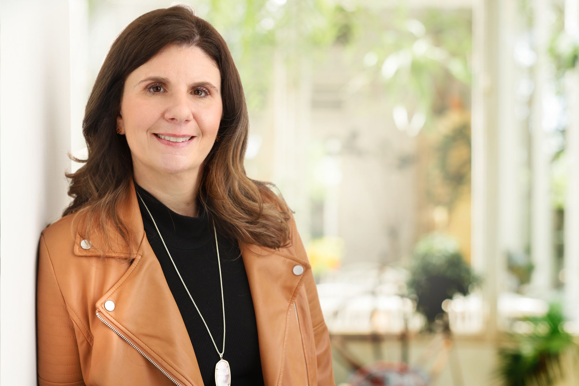 EMDR Therapist Milissa Aronson smiles at the camera inside a warm and welcoming office