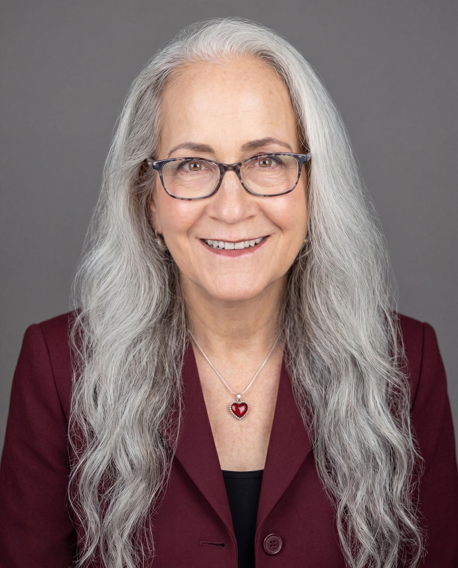 S. Abigail McCarrel, LCSW, smiling warmly in a maroon blazer, offering online parent coaching therapy for neurodivergent kids across California