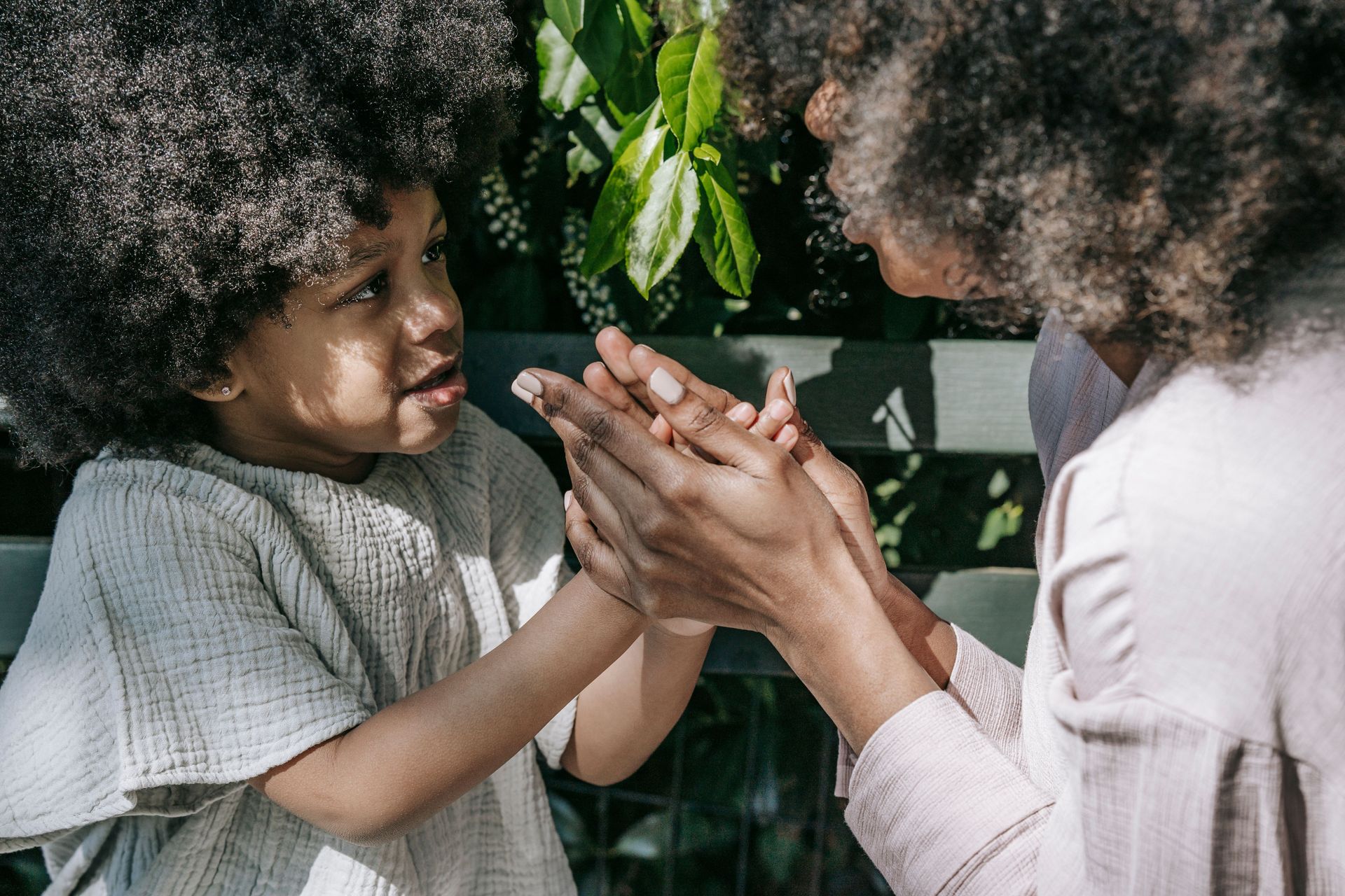 Mother and child holding hands, connecting through conscious parenting