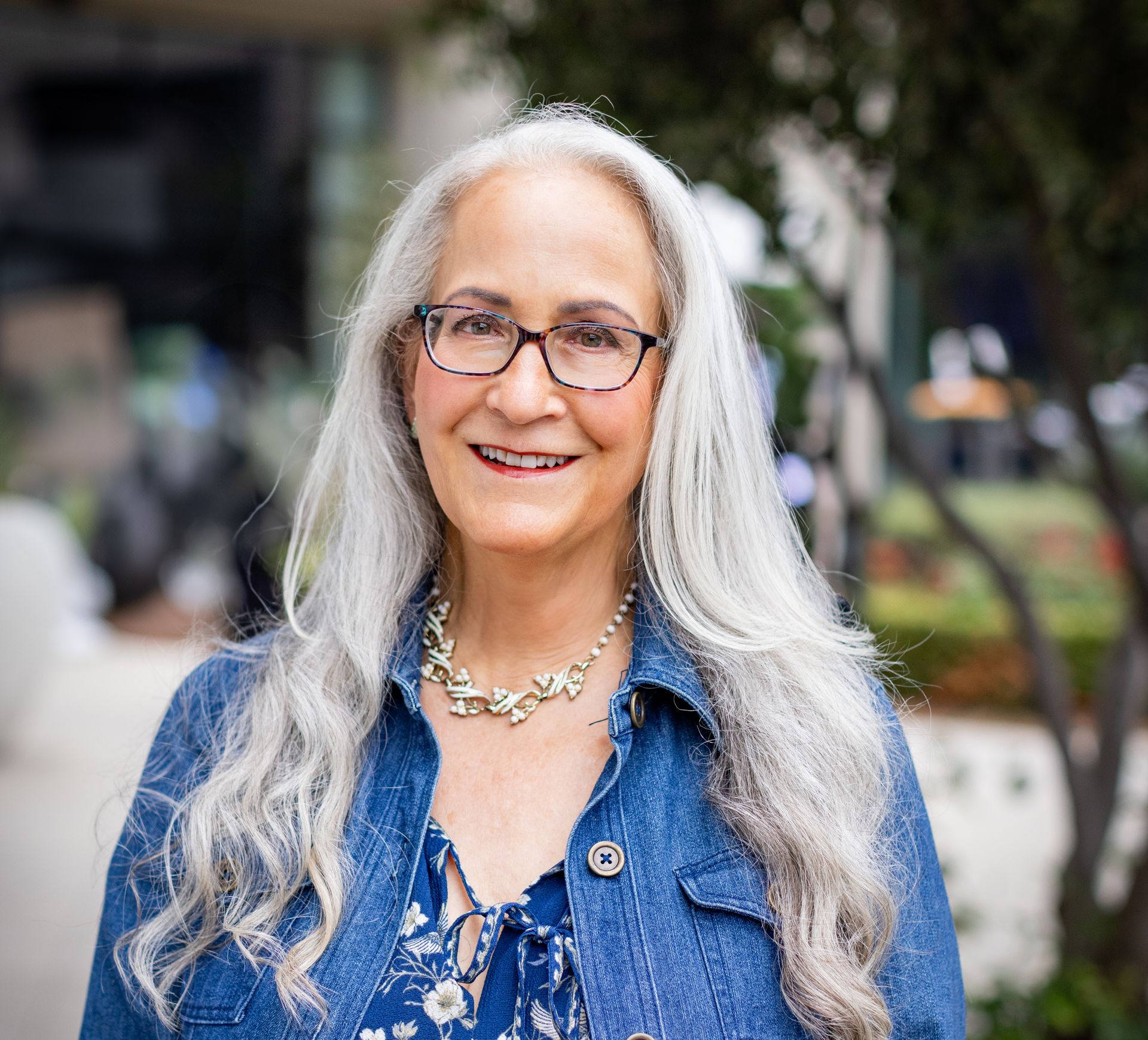 Text reading ‘Parenting an Angry Child’ appears alongside an image of Abby McCarrel, a warm and experienced psychotherapist with long silver hair and glasses, seated outdoors. The image reflects parent counseling and online family therapy in California, helping parents understand anger as a signal of unmet needs and support their child through co-regulation, emotional safety, and connection.
