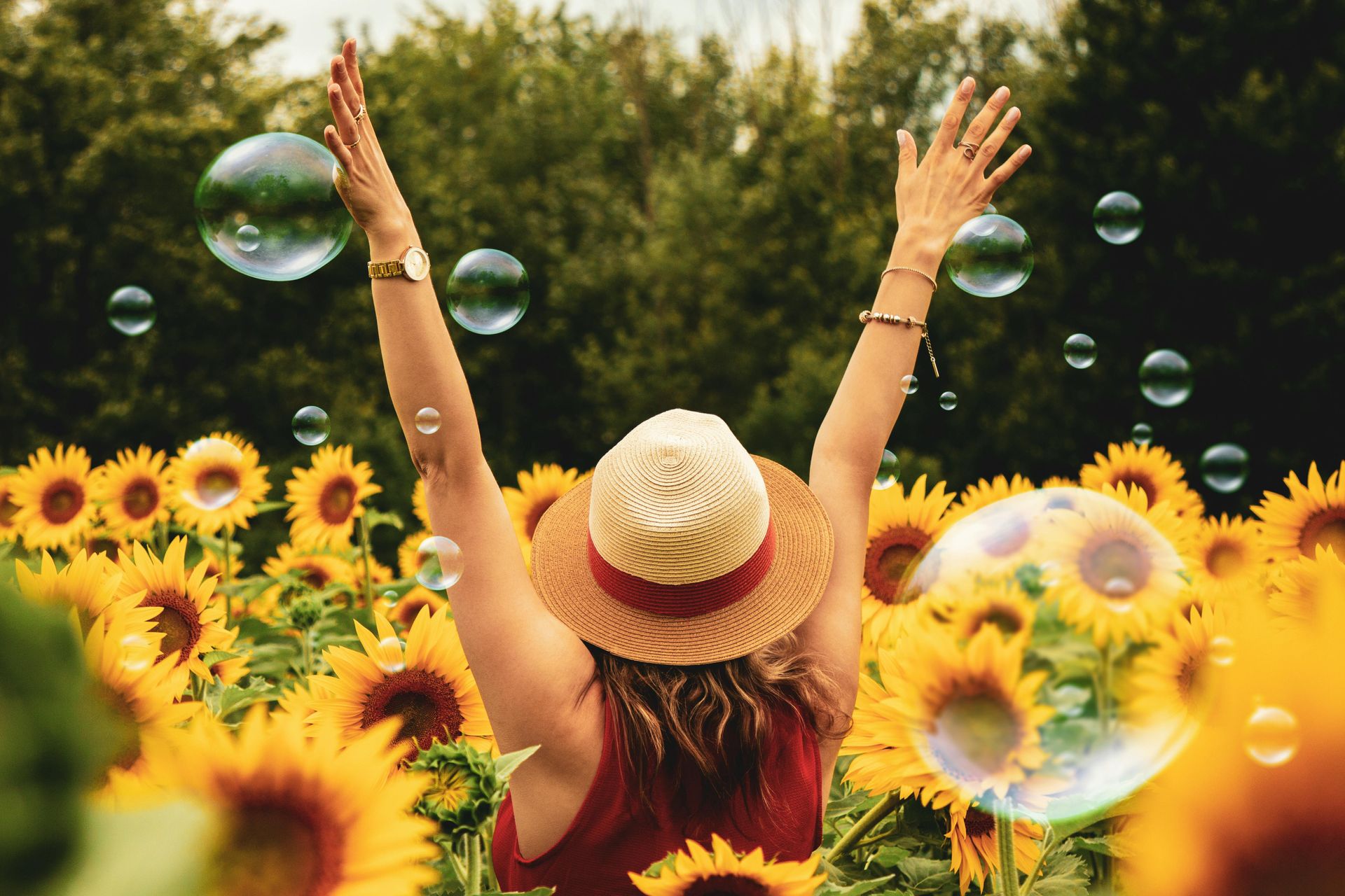 habits that improve mental health, woman with raised arms in field of sunflowers