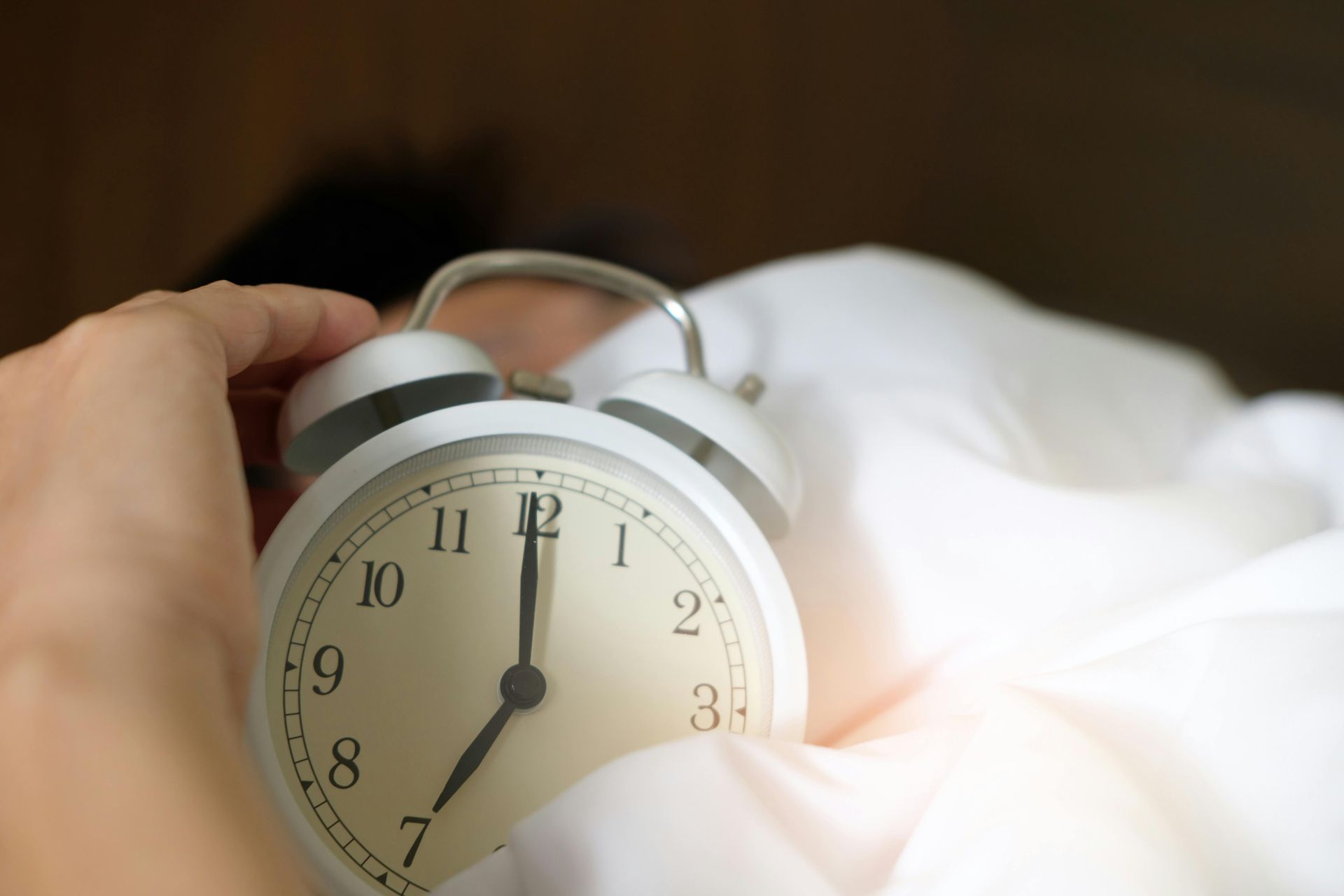 an alarm clock in sheets being turned off. Habits to improve mental health