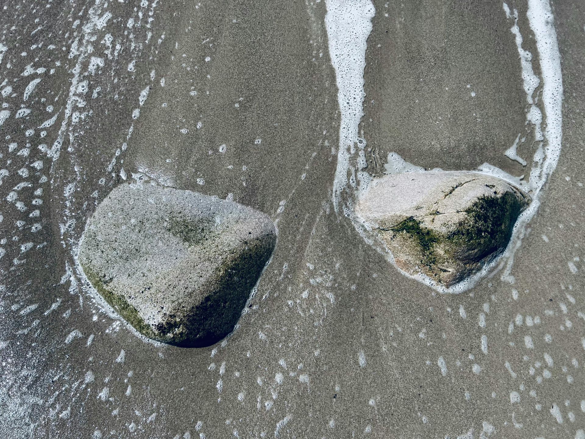 two rocks on a beach, as water flows around them. "Therapist near me" Anchorage Stellar Insight Counseling