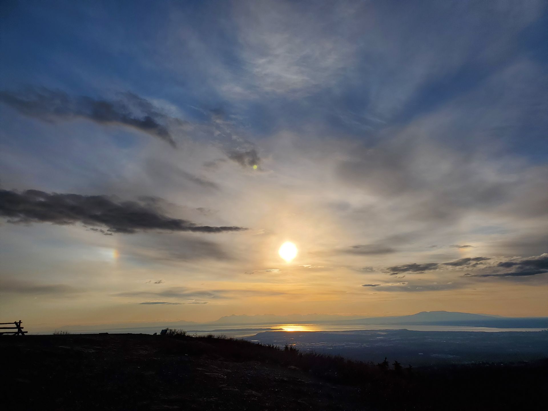 Picture of partial sundog overlooking Anchorage, Cook Inlet, Mount Susitna; the sky fades from blue to gold