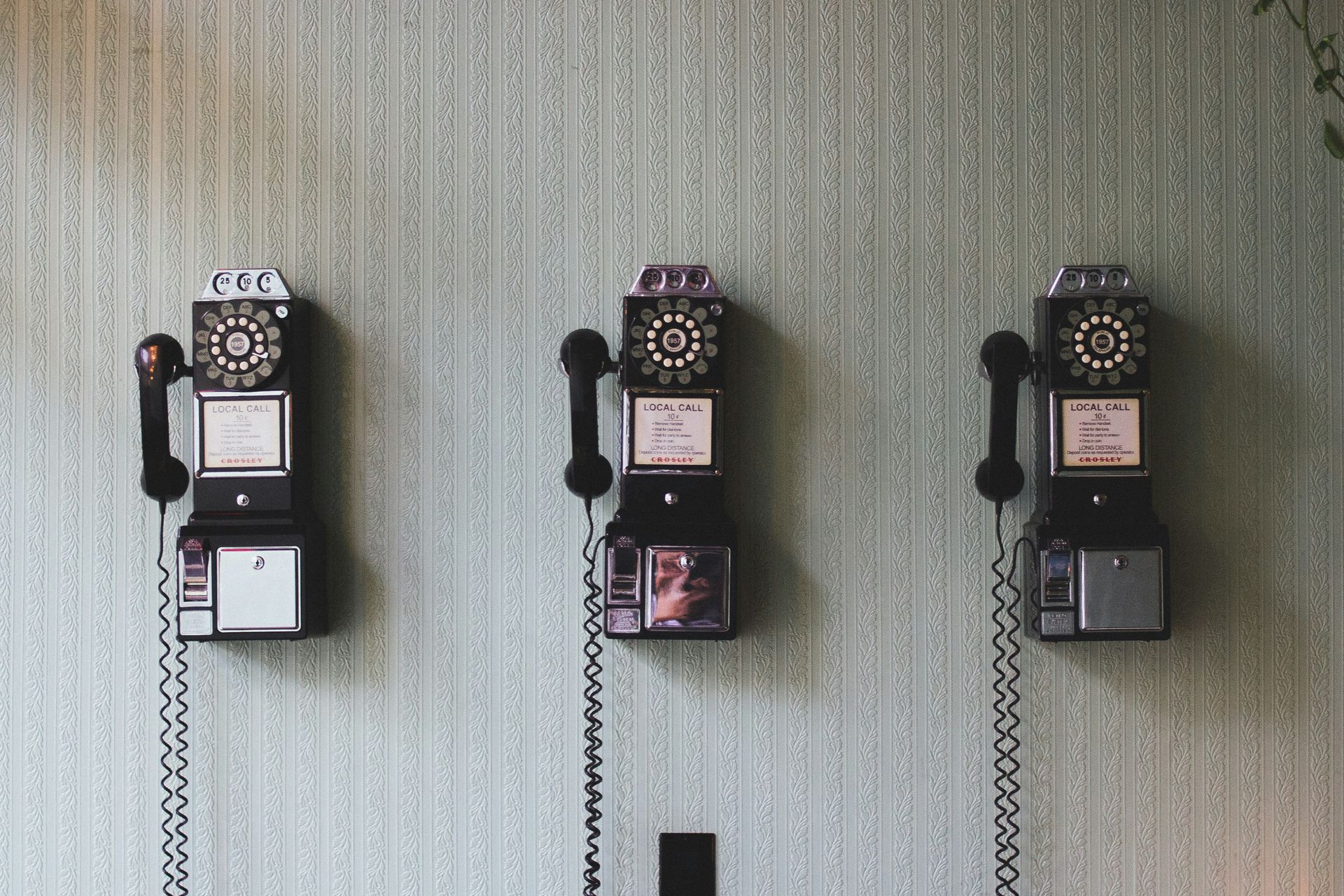 three landline phones hung next to each other on a wall. Chronic Illness (Disability) and Spoon Theory | Chronic Disease & Mental Health