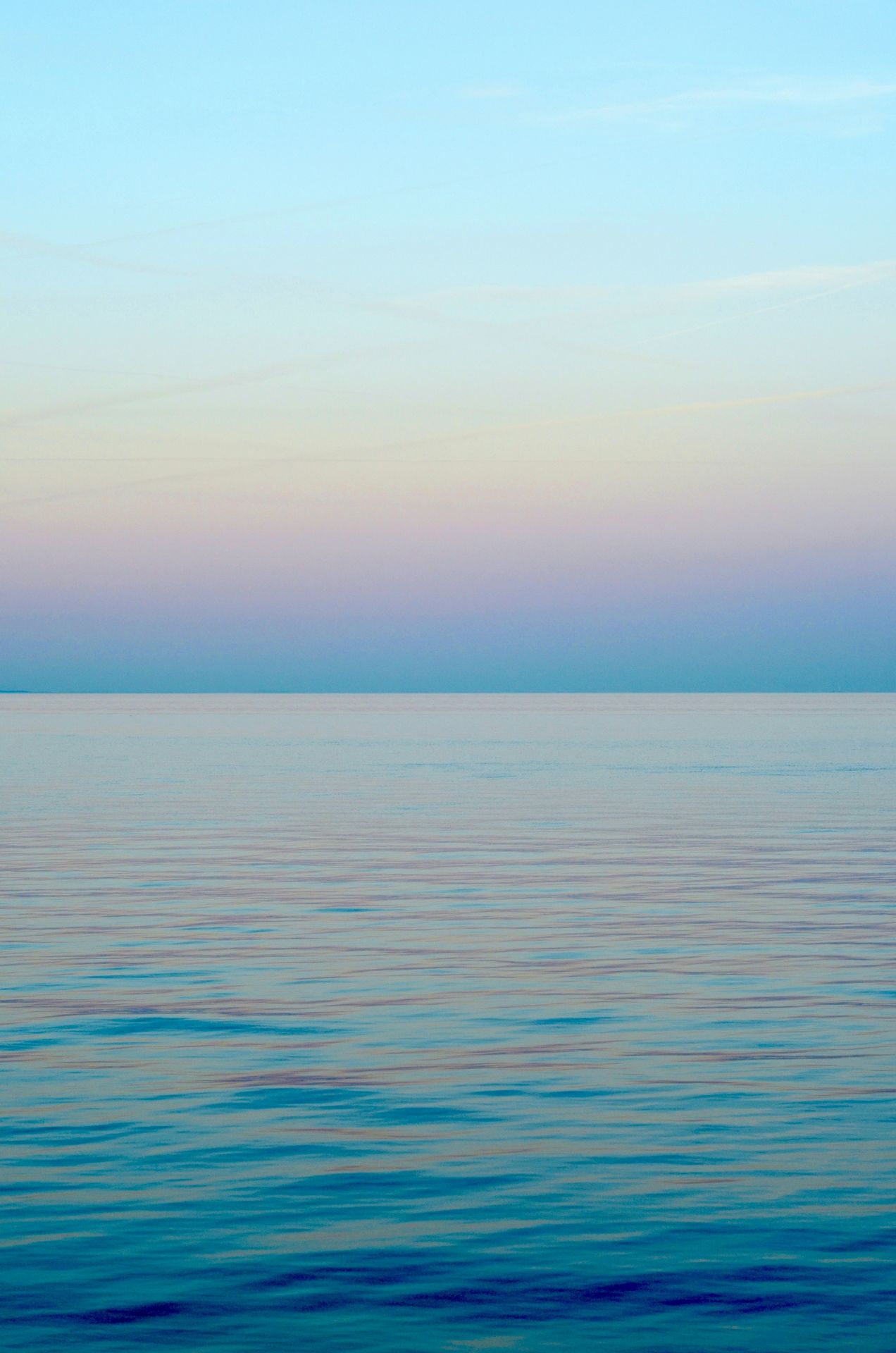 light blue sky over calm ocean