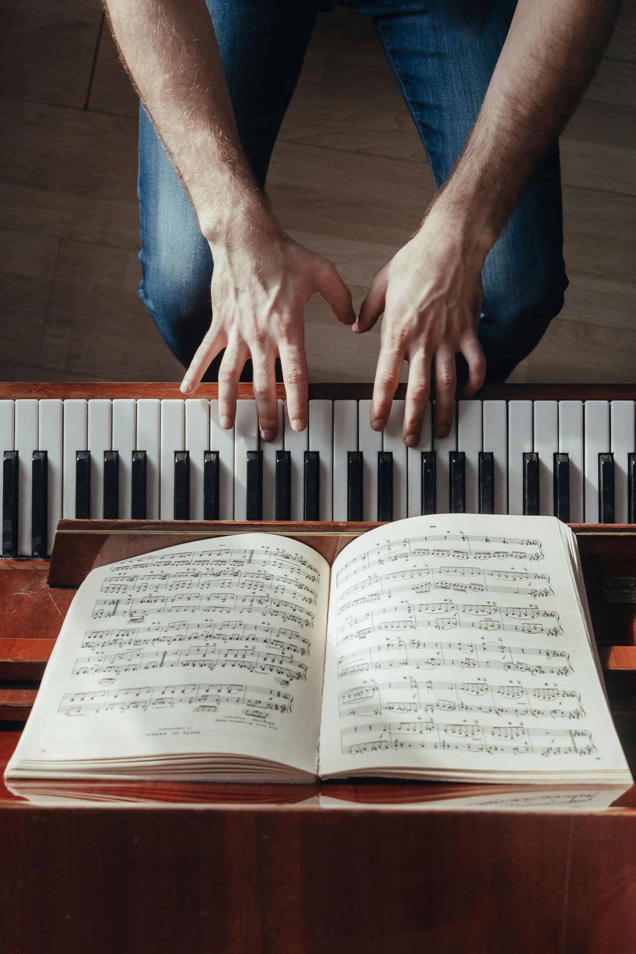 white hands playing the piano as viewed from above. Habits that improve mental health