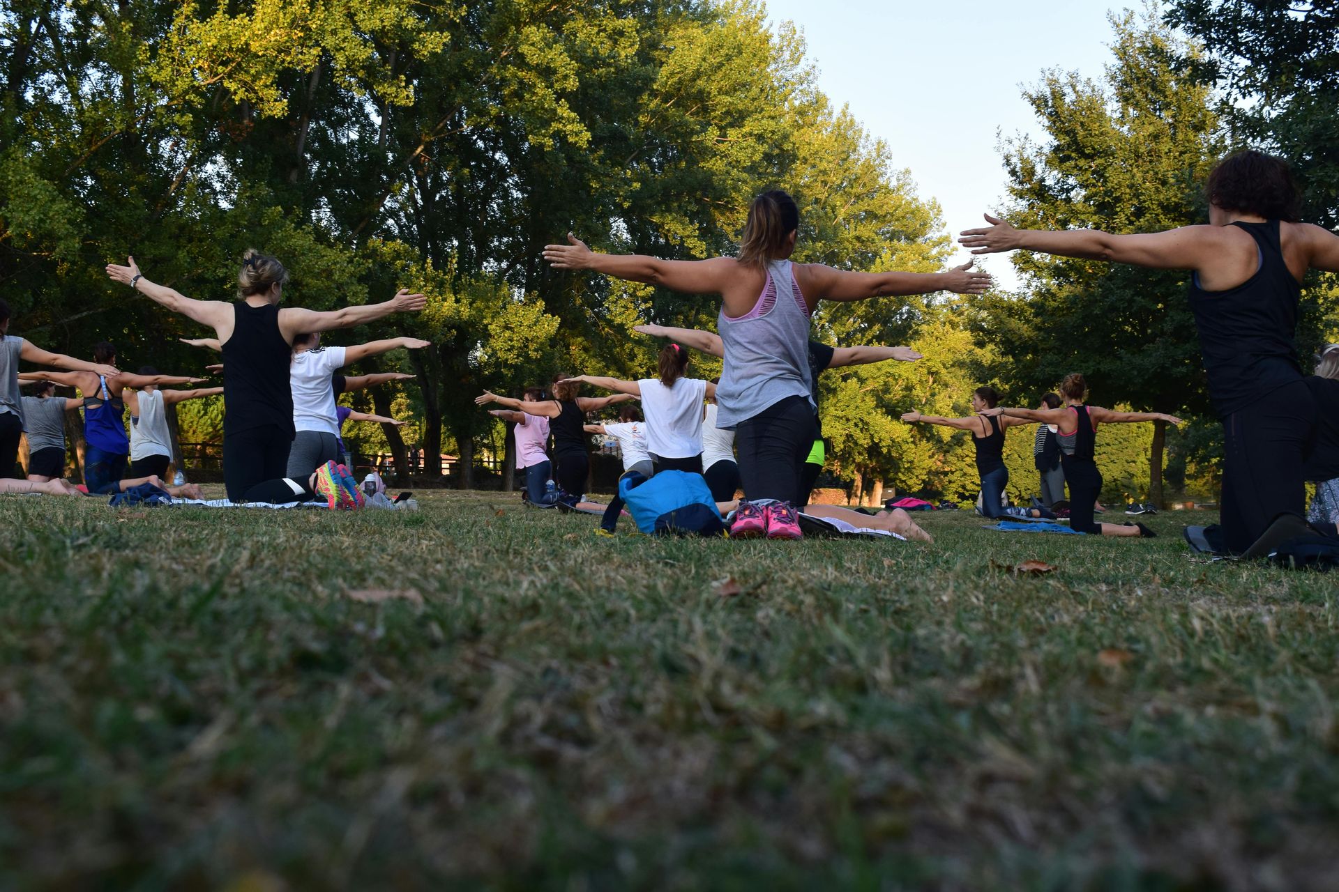 Group of people outdoors practicing yoga. 45 regulation activities to boost well-being