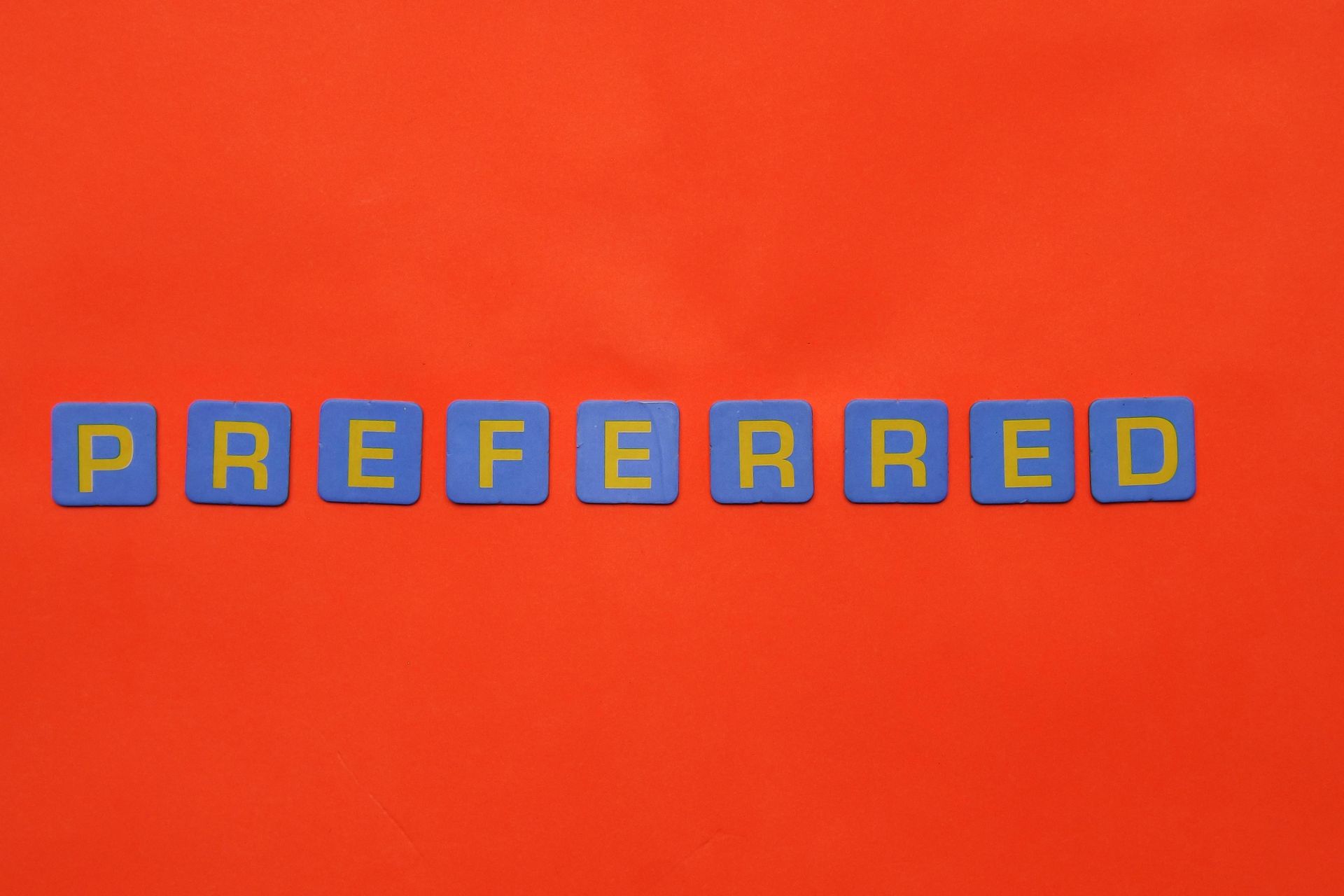 red background with blue letter tiles spelling "Preferred". | Anxiety Depression Trauma Therapist in Anchorage, Alaska