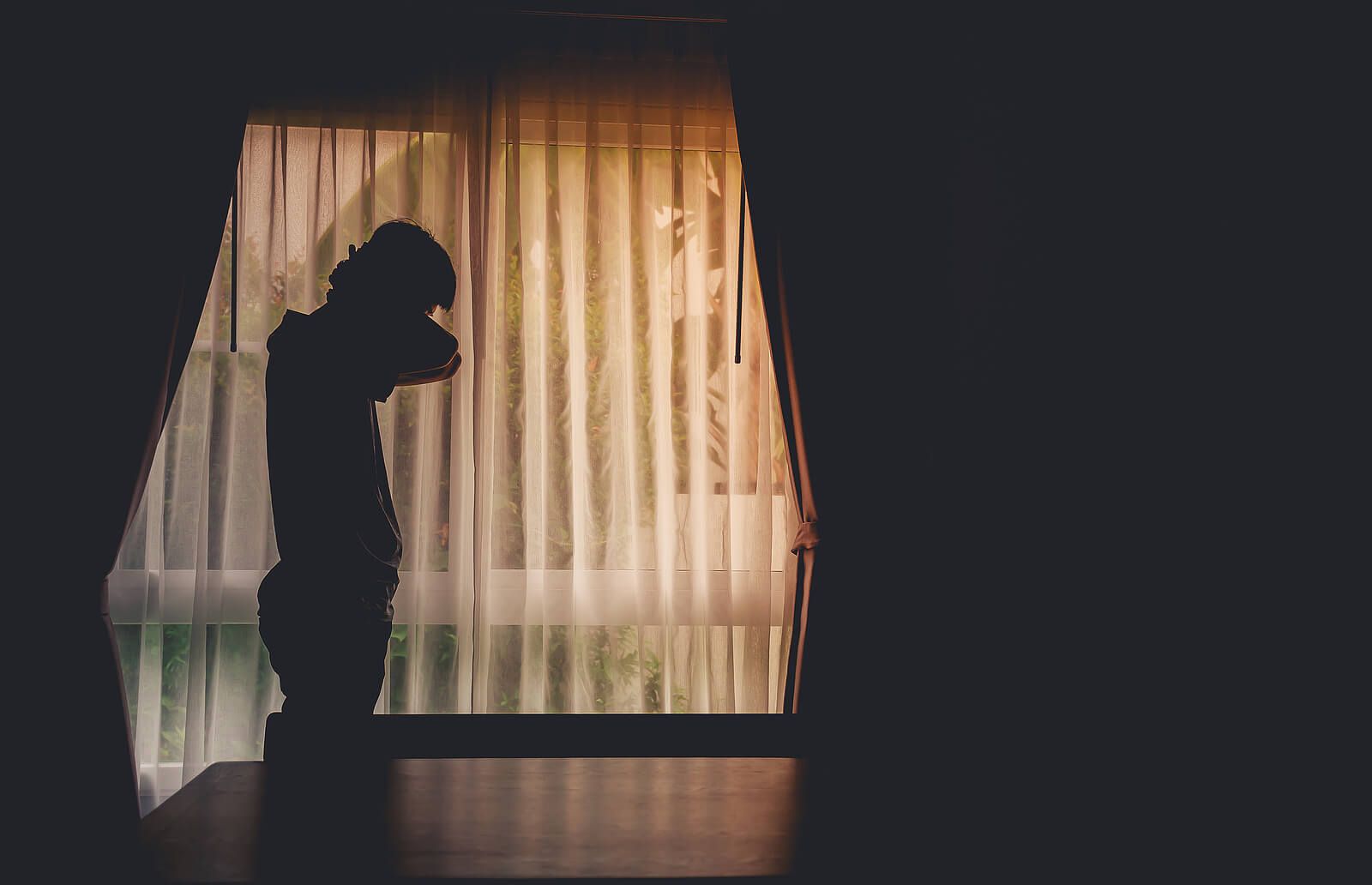 A man standing alone in front of a large window | grief counseling san francisco, ca | grief therapist in san francisco, ca | grief therapy in san francisco, ca |  94609 | 94061 | 94941