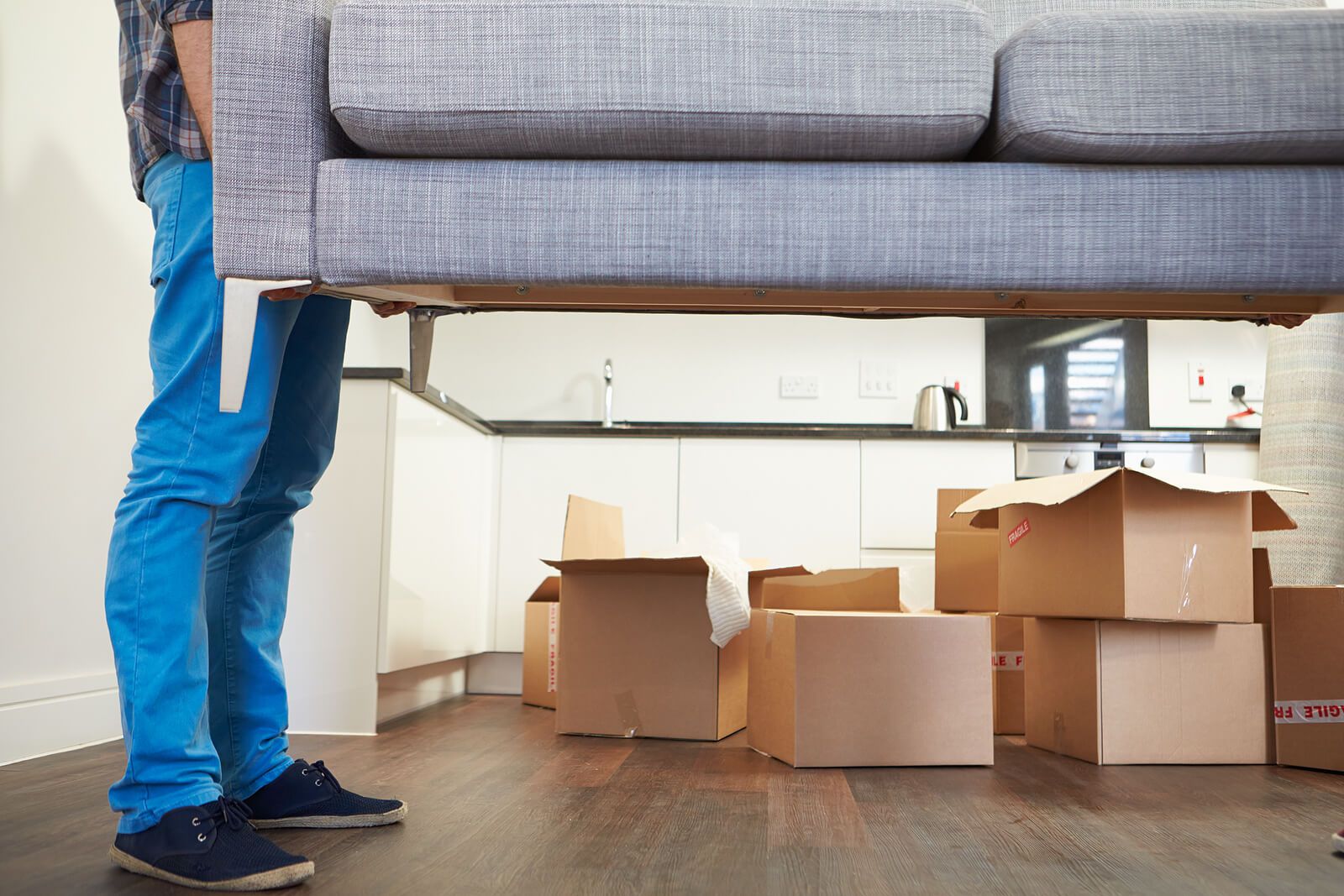 A man holding up a gray couch surrounded by moving boxes | grief counselor san francisco | grief counseling san francisco, ca | grief therapy in san francisco, ca | 94539 | 94110 | 94112