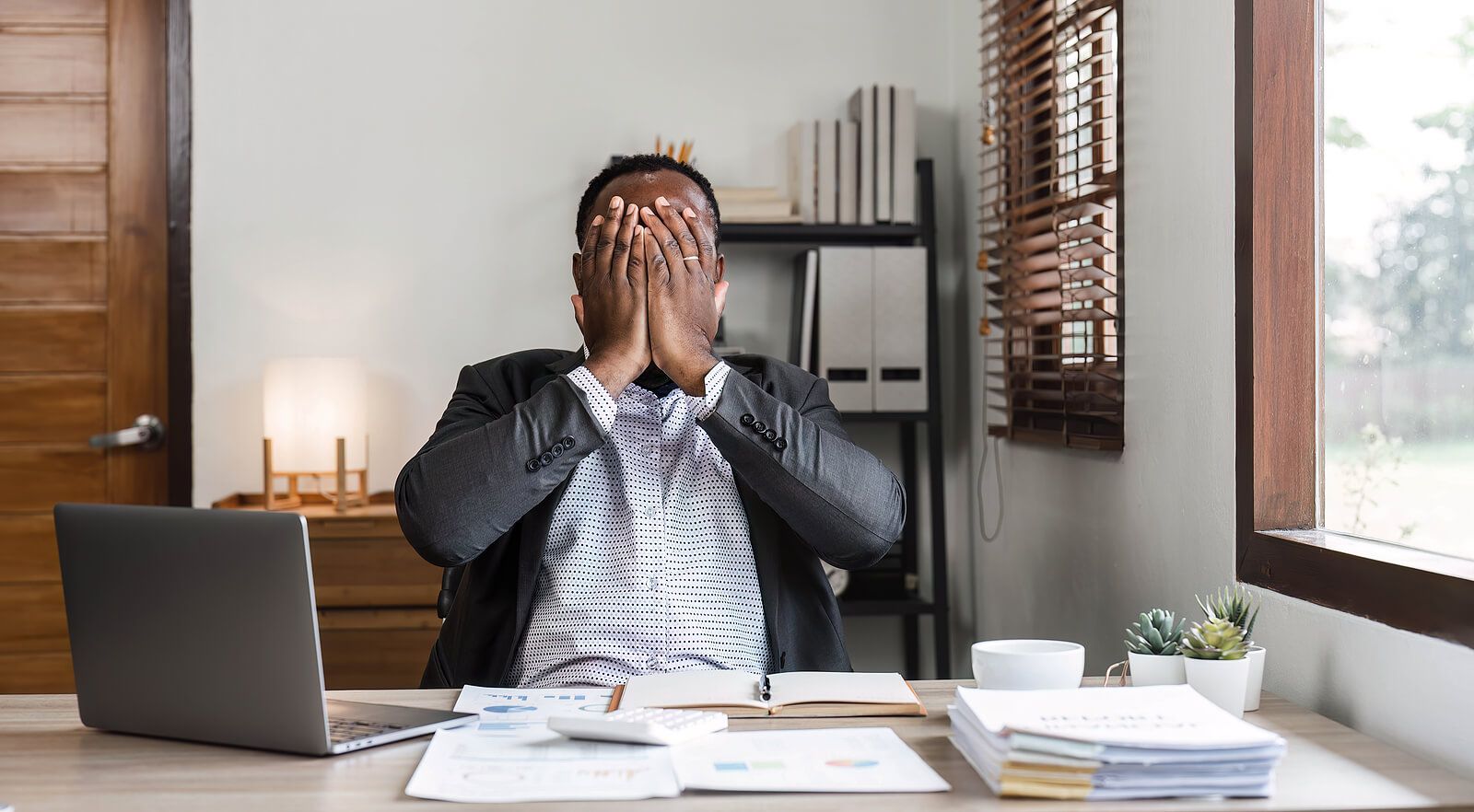 A man covering his face while working showing distress | counseling for men san francisco | men's therapy san francisco, ca | men's therapist san francisco, ca | 94607 | 94608 | 94609