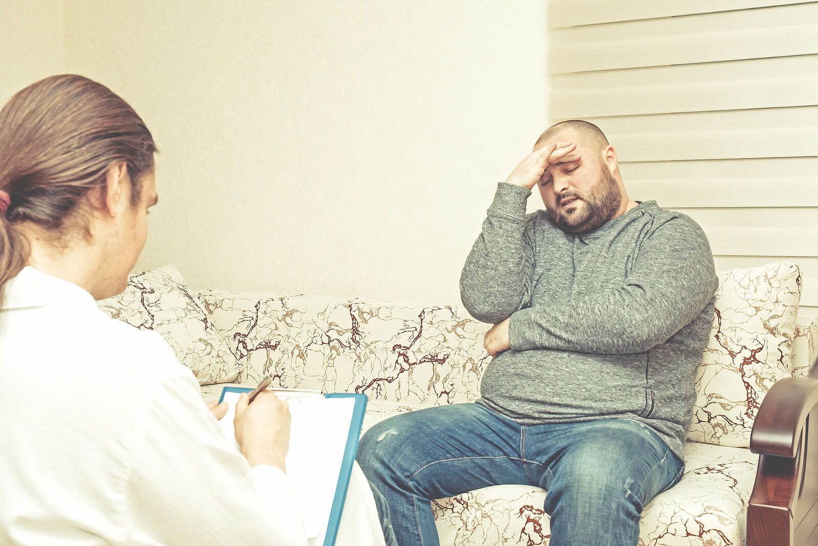 A man talking to a grief counselor while rubbing his temples | grief therapist in san francisco, ca | grief therapy in san francisco, ca | grief counseling san francisco, ca | 94110 | 94112 | 94116