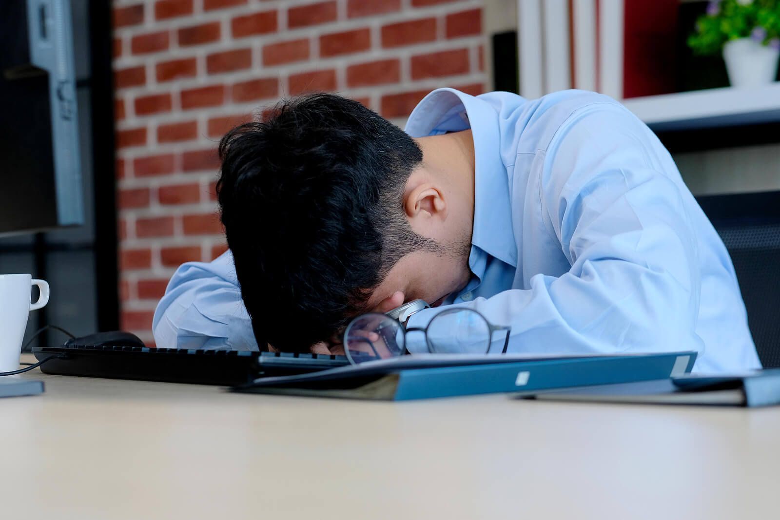A tired man resting his head on his keyboard | counseling for men san francisco | men's therapist san francisco, ca | men's therapy san francisco, ca | 94607 | 94608 | 94609