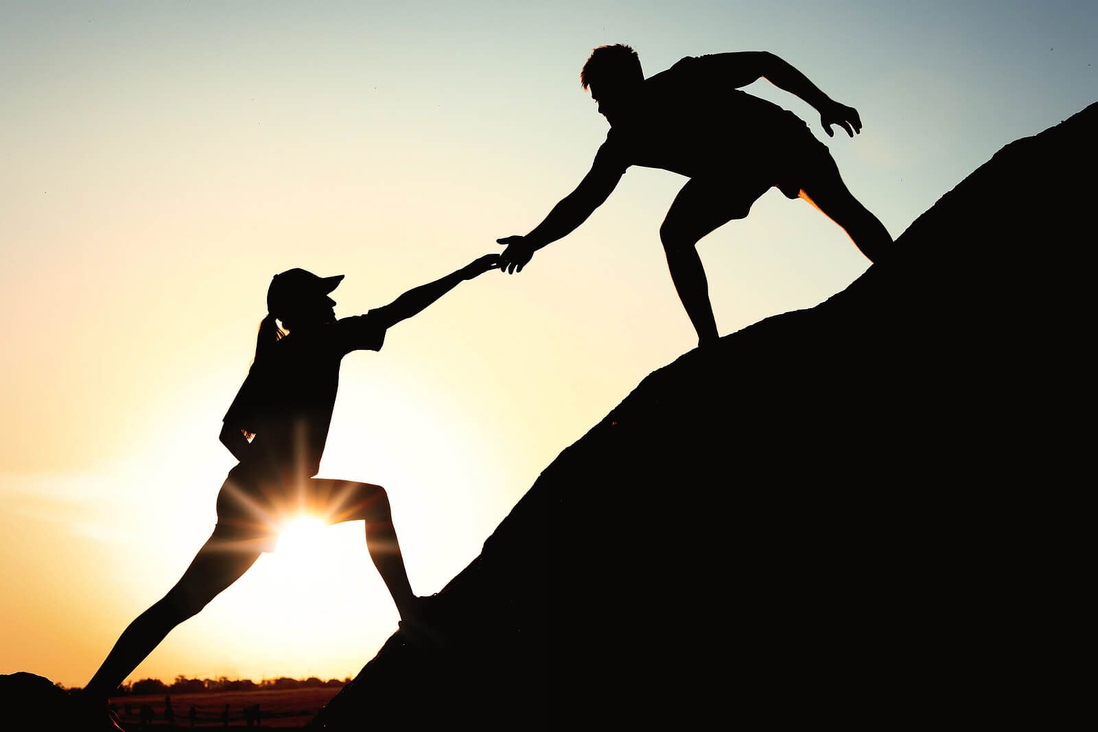 An individual reaching out to another on a mountain side | grief therapist in san francisco, ca | grief therapy in san francisco, ca | grief counseling san francisco, ca | 94110 | 94112 | 94116