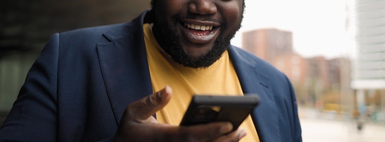 A man smiling while looking at his phone | A couple sitting away from each other on the couch | grief counselor san francisco, ca | grief counseling san francisco | grief therapy in san francisco, ca | 94121 | 94607 | 94608