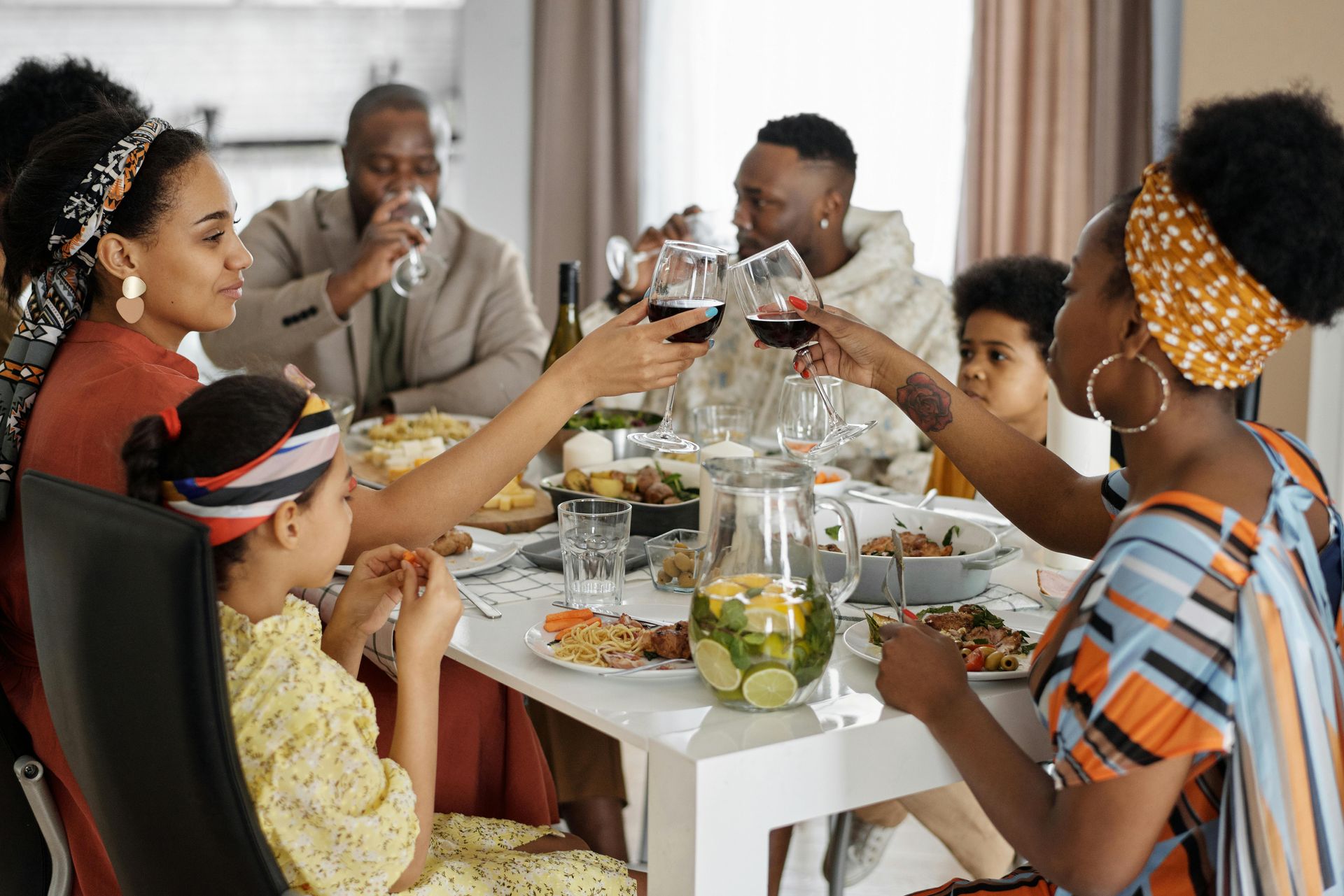 large family at the dinner table holding up wine glasses and enjoying time together