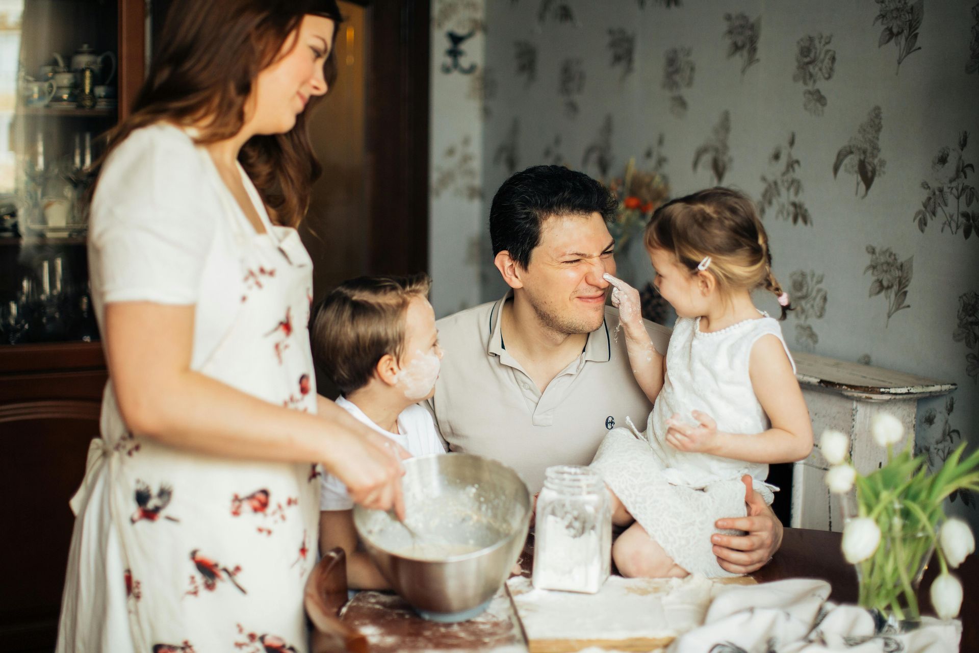 cis-gender family with two kids baking in the kitchen with flour