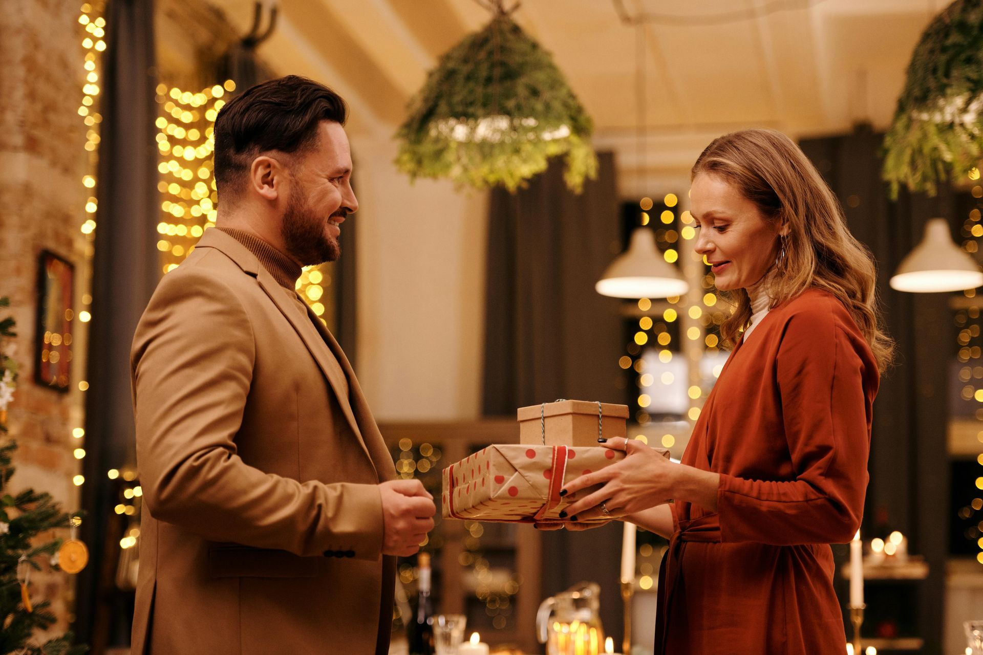 cis gendered white couple the man is giving the woman a gift he has a big smile on his face she looks pleased, Uplift and Connect Counseling
