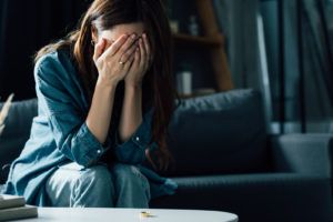 Photo of a woman covering her face with her hands in a dark room. Don't face your trauma alone. With trauma therapy in San Francisco, CA you can begin to manage your unresolved trauma symptoms.