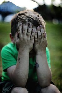 A small boy holding his face after being punished. Represents the need for parenting counseling in Katy, TX 77494