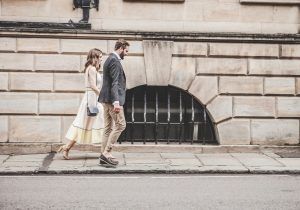 A heterosexual couple walking down the sidewalk holding hands after leaving their couples therapy session