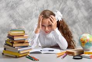 a young girl looking stressed surrounded by school items and books, Children and Resiliency blog, counseling center at cinco ranch, katy texas, fulshear texas, richmond texas, therapy.