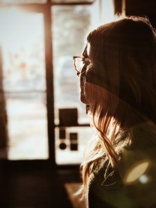 A woman staring out the window and reflecting on her self-care after learning about healthy boundaries in her women's group therapy session in Katy, TX 77494