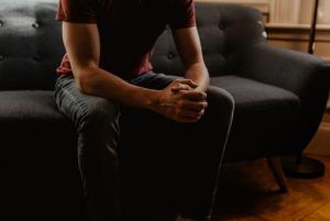 Man sitting on the couch during trauma therapy in Katy, TX 77494