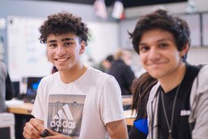 Two teenage boys that are best friends sitting together at lunch having fun after learning how to handle their emotions in group counseling in Katy, TX 77494