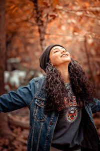 girl standing in a field of trees looking happy, overcoming depression, Teen Depression-Is it a Phase? What You Can Do to Help blog