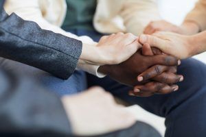 Teens holding the hands of an individual to show support during teen group therapy in Katy, TX 77494 to show one another that they are not alone.