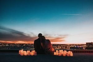 A couple sitting looking at the sunset surrounded by candles. Represents the need for couples therapy to resolve conflict in Katy, TX 77494
