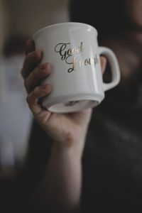 A person holding a coffee mug that states "good enough." Represents the need for counseling for perfectionism in Katy, TX