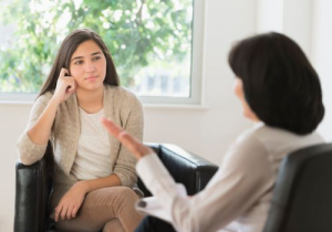 A young adult female with ASD in a talk therapy session with her counselor in Katy, TX 77494