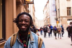 A male teenager walking down the street listening to music after learning in cognitive behavioral therapy that his thoughts are not threats 