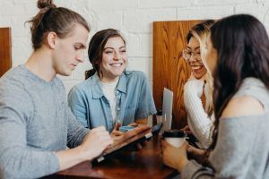 Friends, coworkers, or students talking at a lunch or dinner table, talking, assertiveness blog, relationship, begin counseling in Katy Texas, Fulshear Texas, Richmond Texas