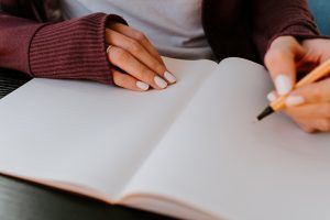 A woman about to begin journaling as one of her healthy coping strategies she learned during her cognitive behavioral therapy session in Katy, TX 