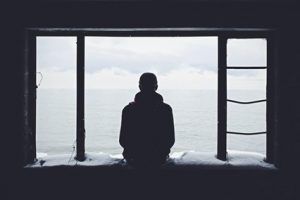 man looking out a window, depression, Shame and Chronic illness blog, begin therapy today in katy texas, counseling center at cinco ranch.