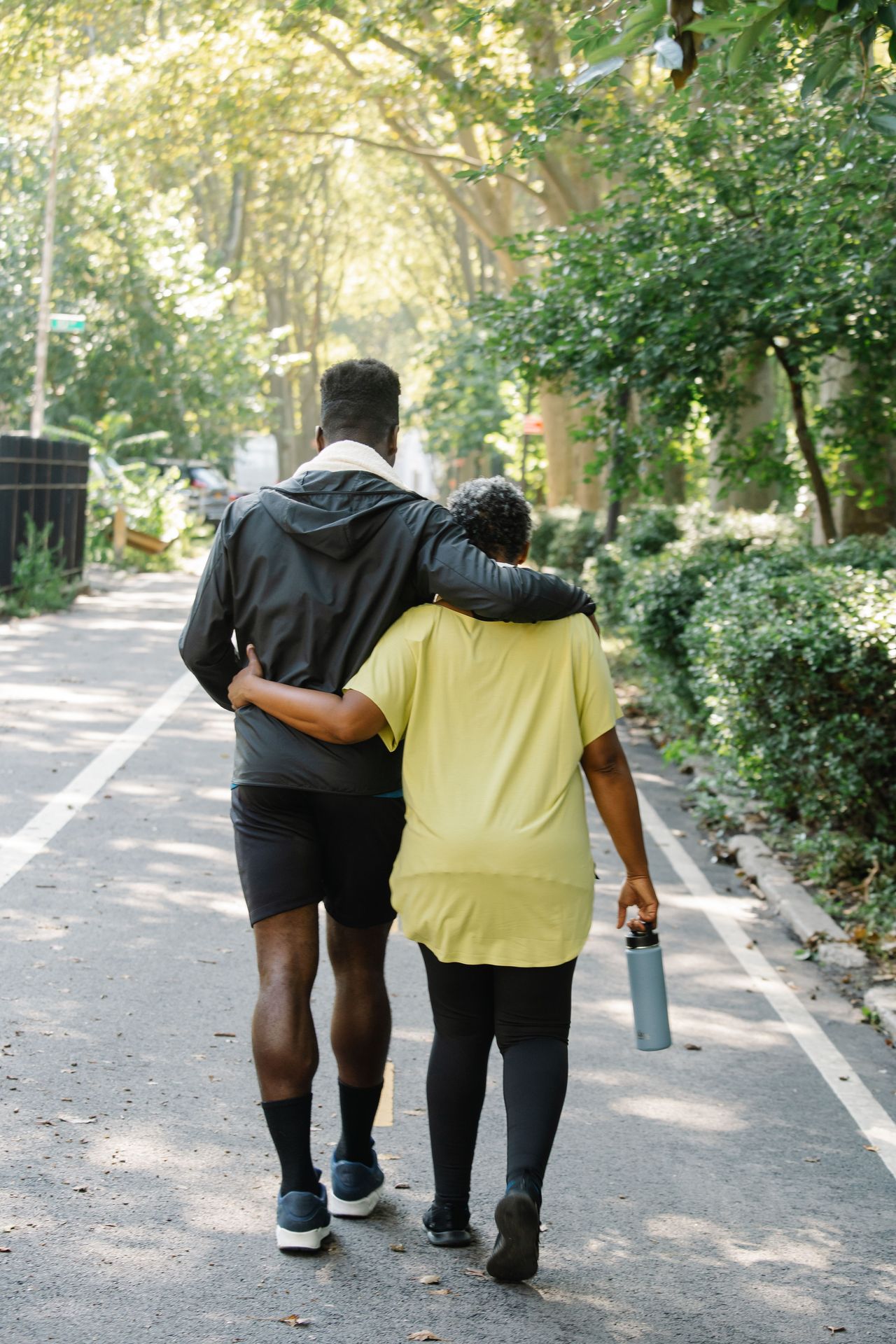 A couple walking together along a leafy path