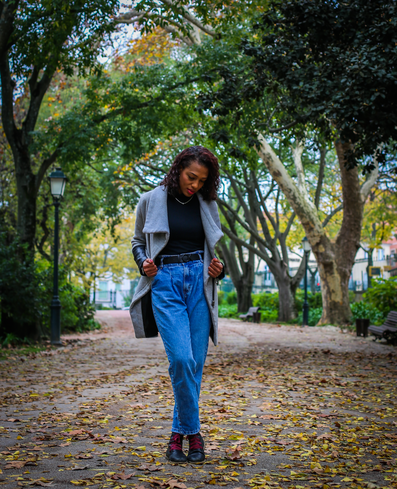 A woman walking along a tree-lined path