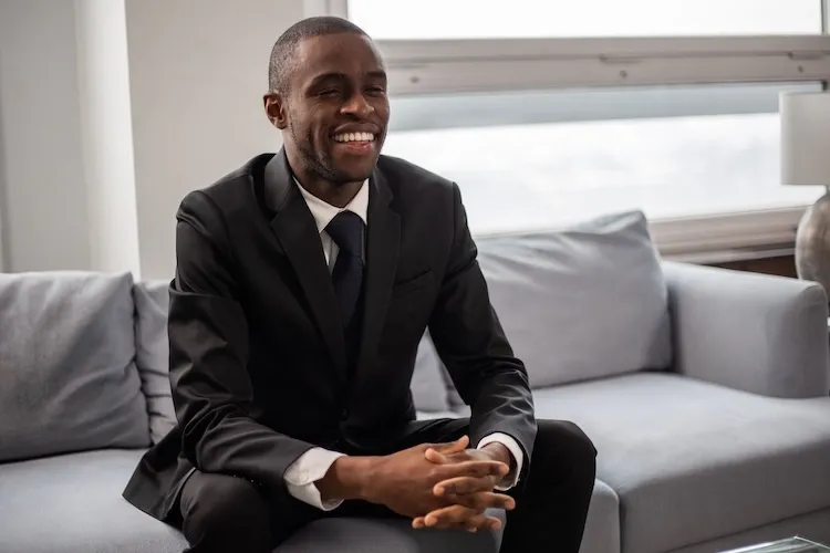 A man sitting on a couch in a suit.