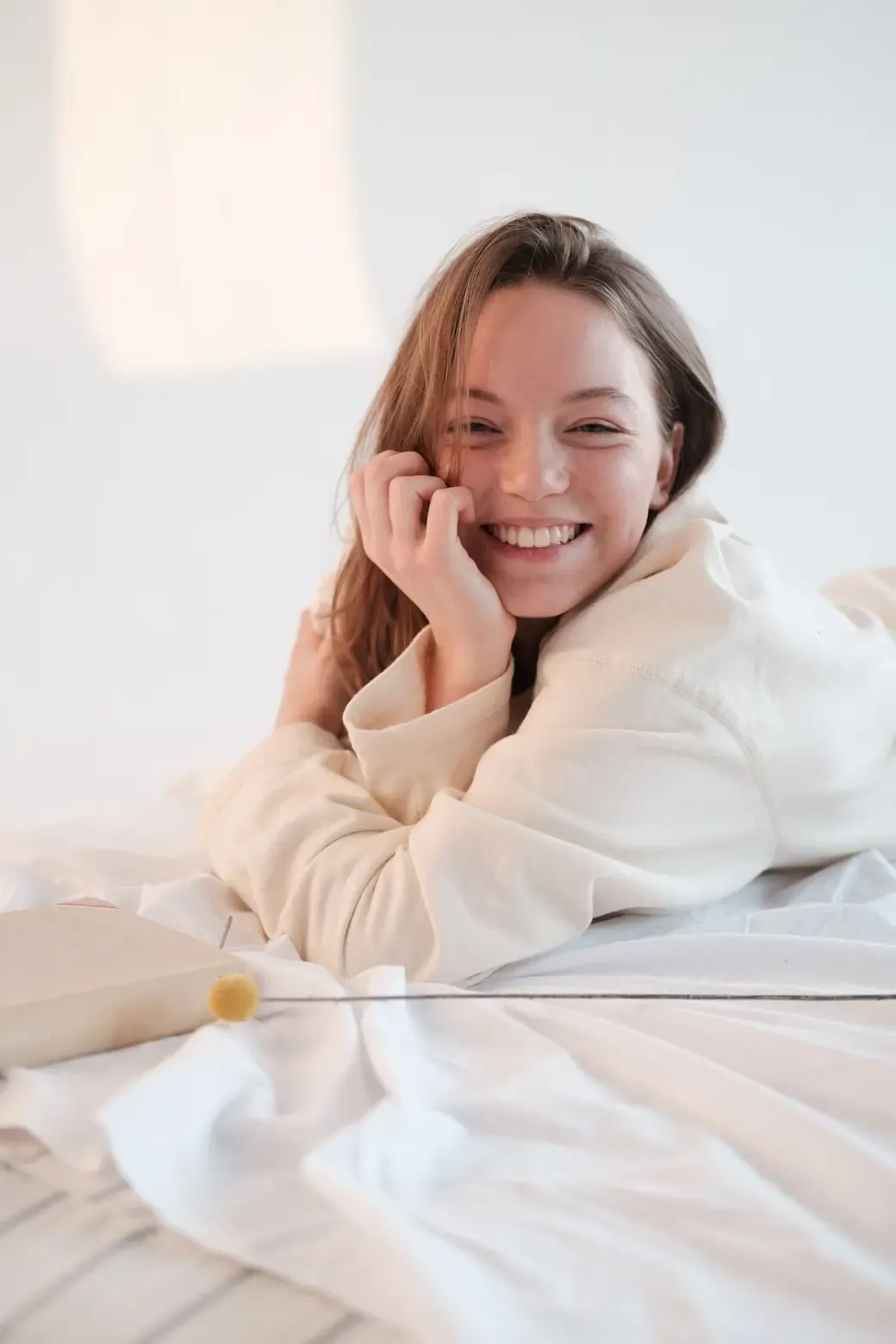 A woman smiling lying in bed.