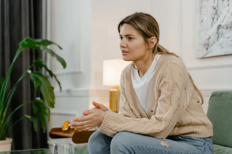 A woman sitting on a couch in talk therapy.