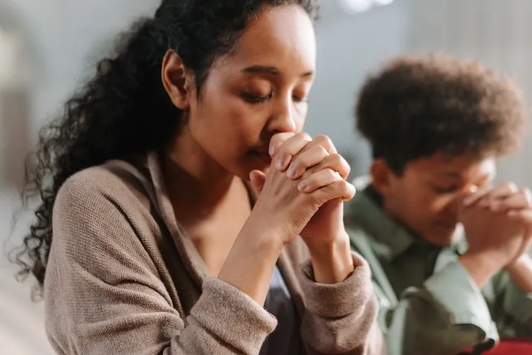 A woman with her hands in prayer.