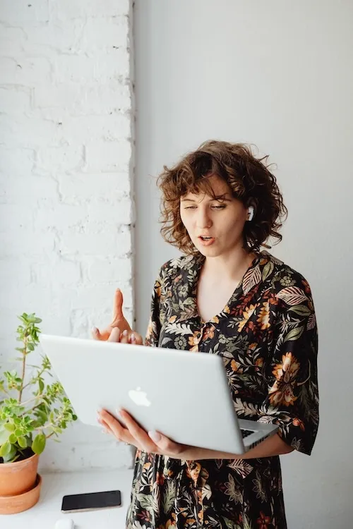 Woman talking to someone on a laptop.