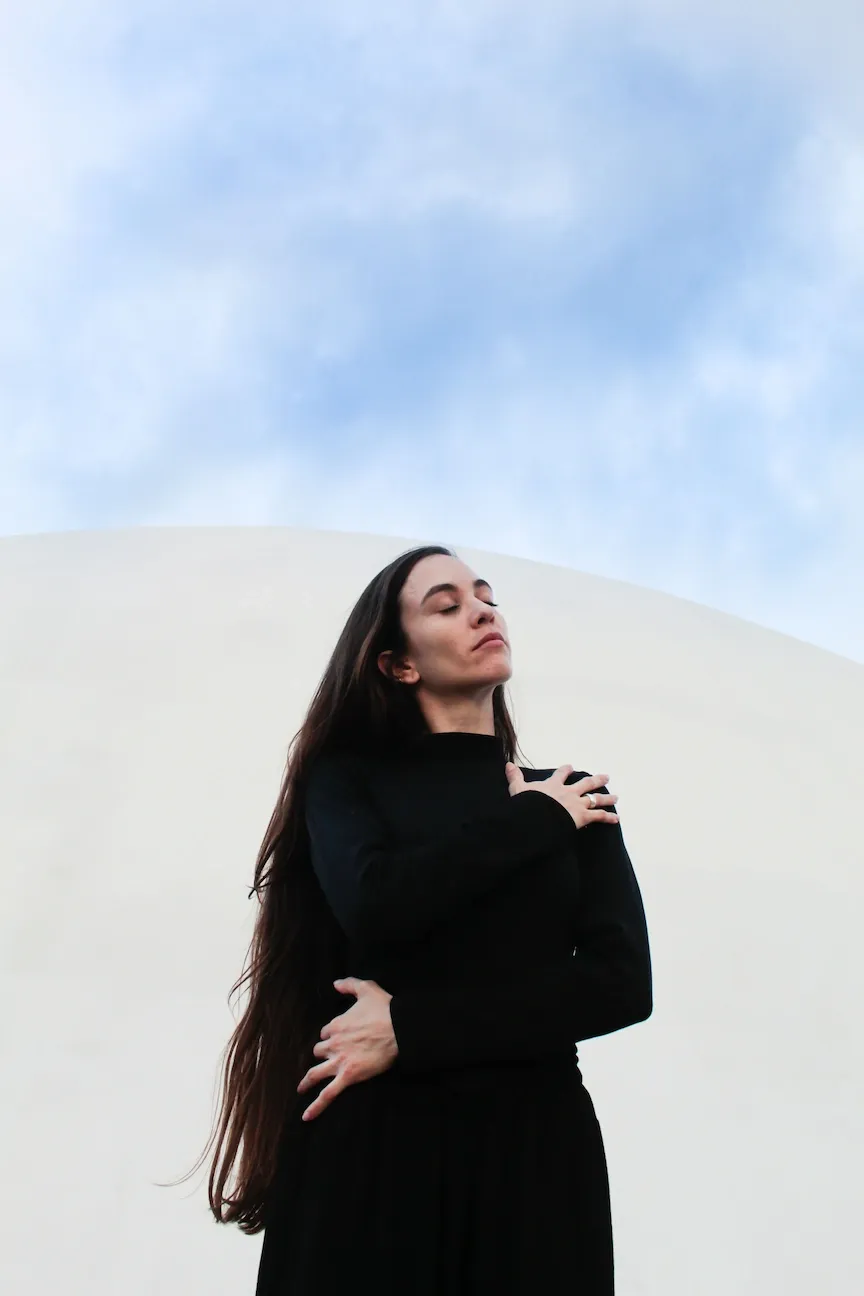 A woman with long hair and eyes closed.